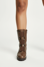 Load image into Gallery viewer, Front view of tan boots on brown-skinned model
